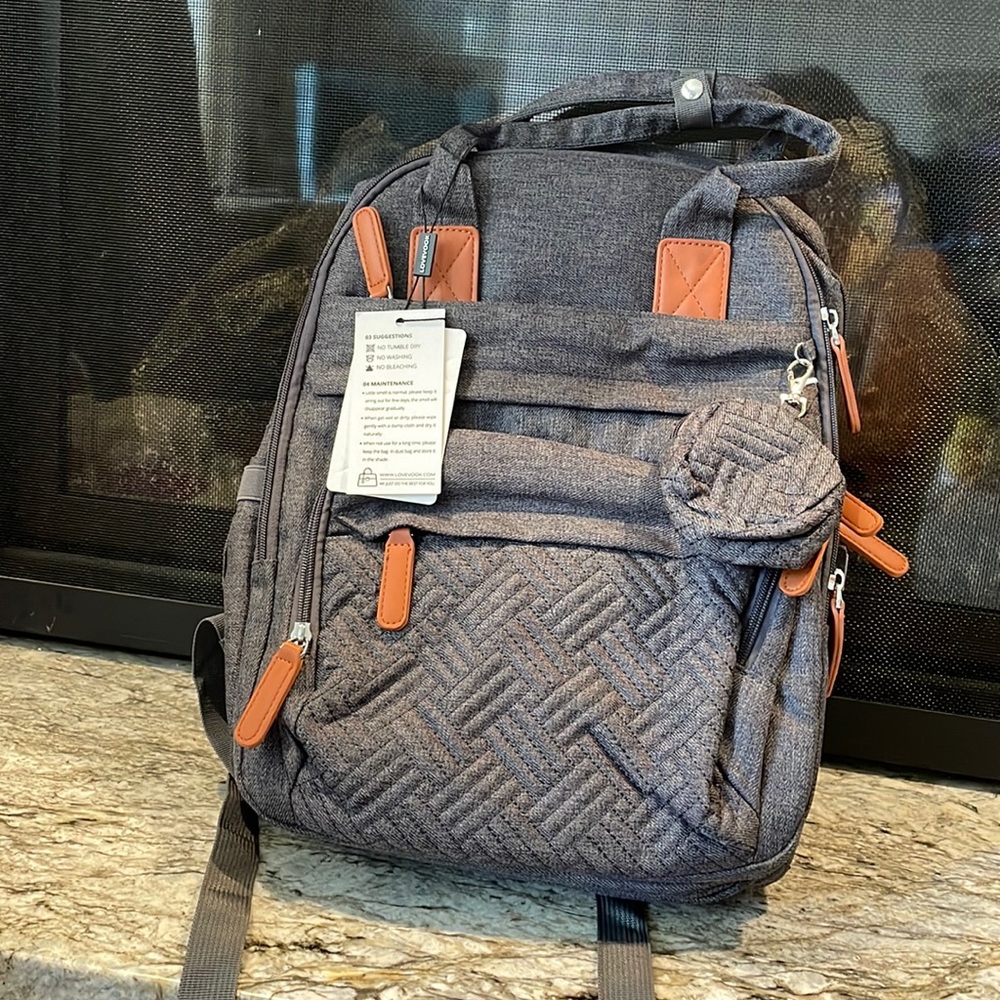 Brand new gray backpack diaper bag. Unzips a collapsible bassinet.